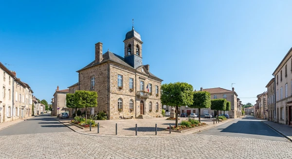 Photographie réelle de la commune de Panazol près de Limoges, montrant un élément caractéristique et reconnaissable du lieu (une rue typique, une place publique, un bâtiment remarquable, une mairie ou un carrefour important) en plein jour. L'image doit clairement identifier Panazol comme un lieu distinct et établi de manière professionnelle, sans personnages en avant-plan, permettant d'illustrer l'une des zones de couverture géographique du garage automobile.